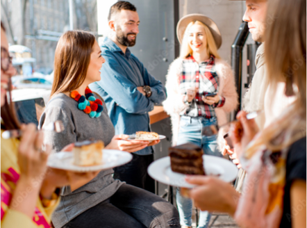 People gathering. They are holding a plate with a piece of cake